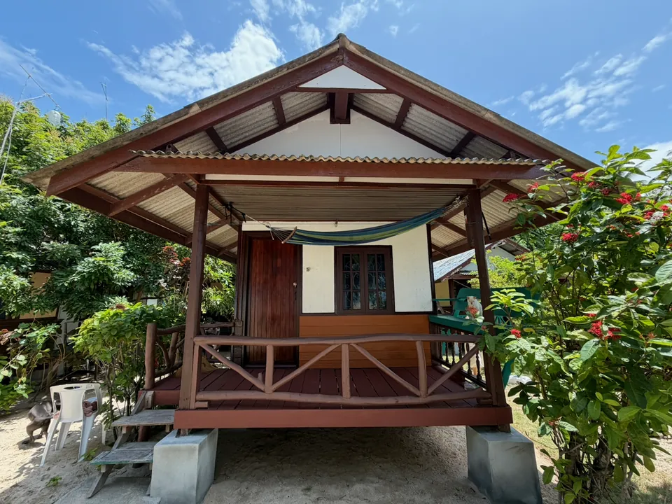 A garden bungalow at Pink's Bungalows, with a hammock slung across its covered balcony